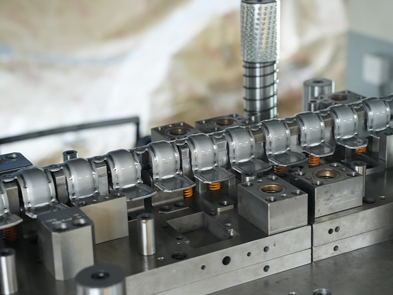 Cad a tharlaíonn taobh istigh de mhonarcha chun páirteanna stampála miotail a dhéanamh?